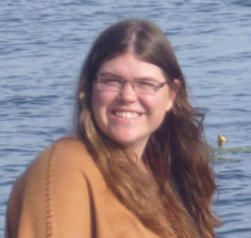 Victoria Reid is dressed in animal skins on the bank of the Pahkakoski lake at Kierikki Stone Age Centre, from her time in Finland.